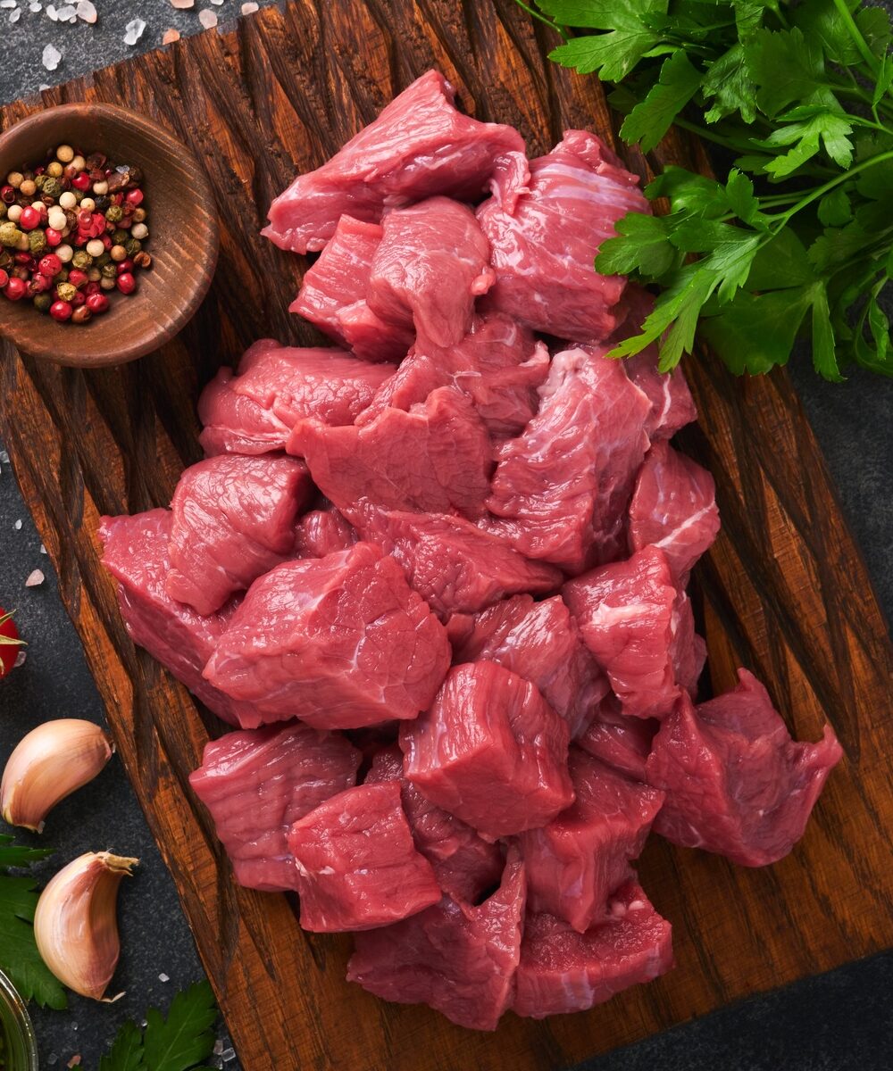 Raw chopped beef meat. Raw organic meat beef or lamb, spices, herbs on old wooden board on dark grey